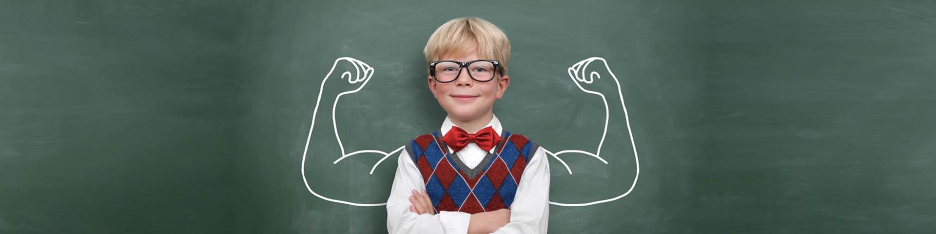 Wir zeigen unsere Muskeln! Junge steht vor Schultafel!