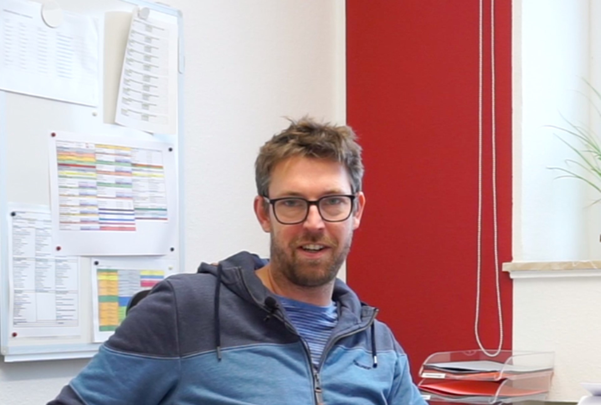 Jonas Eichhorn sitzt an einem Schreibtisch und schaut in die Kamera