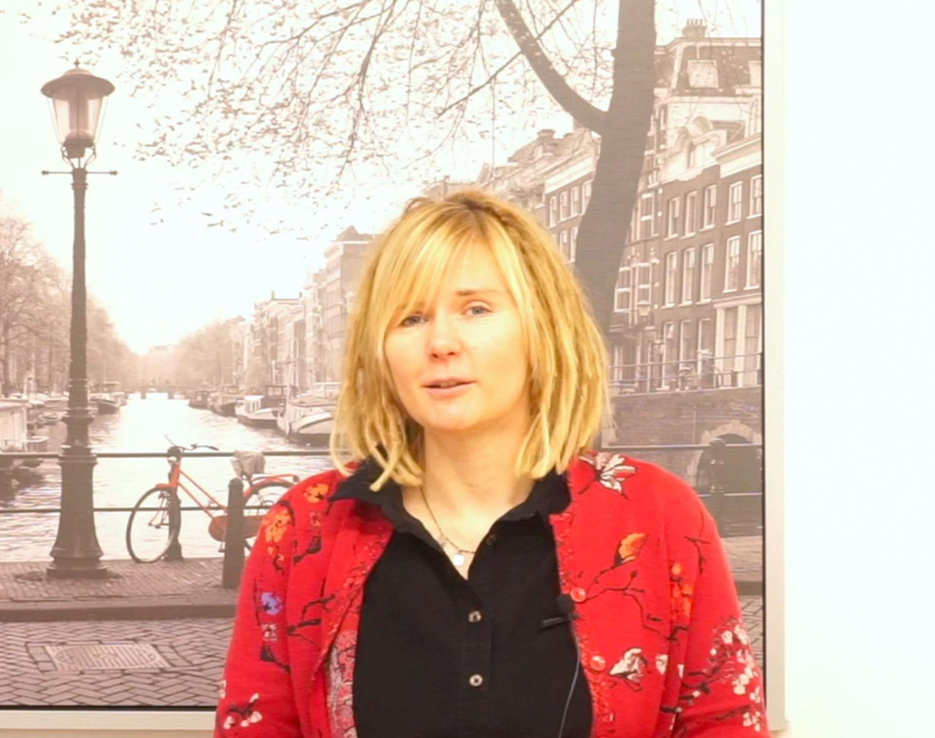 Corinna Stanioch steht vor einem großen Bild und schaut in die Kamera